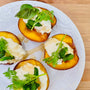 Peaches topped with ricotta, honey, and herbs